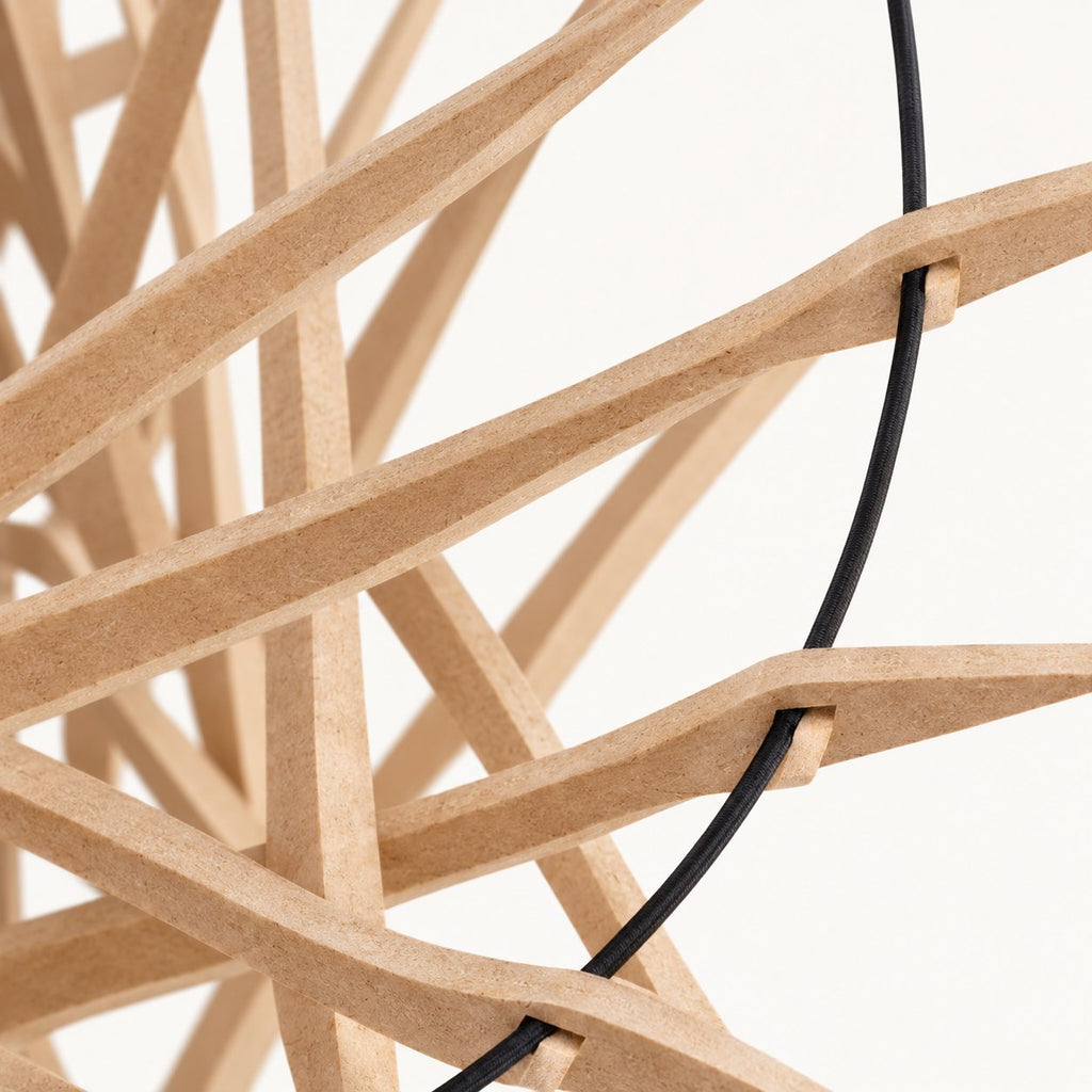 Detail van de MDF-stroken, inkepingen en zwarte elastische rand van Let’s Twist Again Ø106.